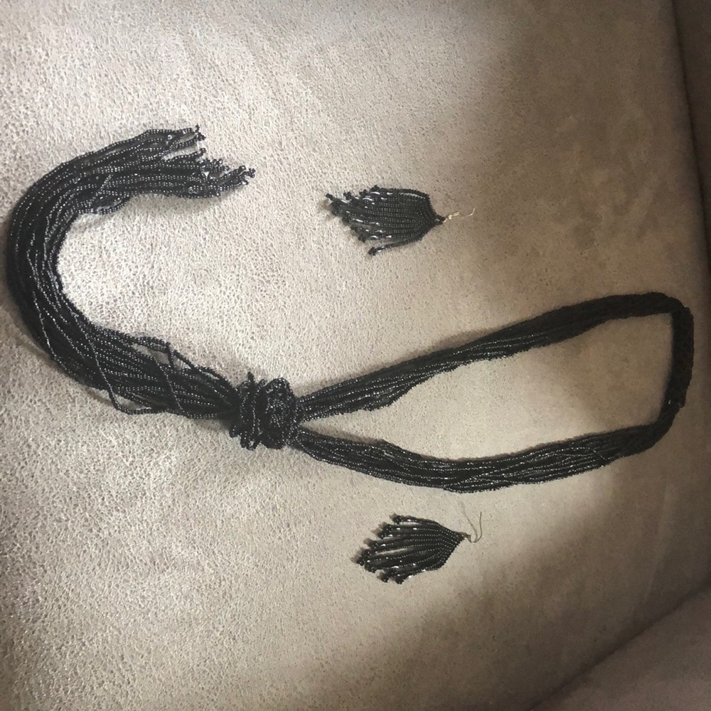 Long black beed necklace with rose design halfway